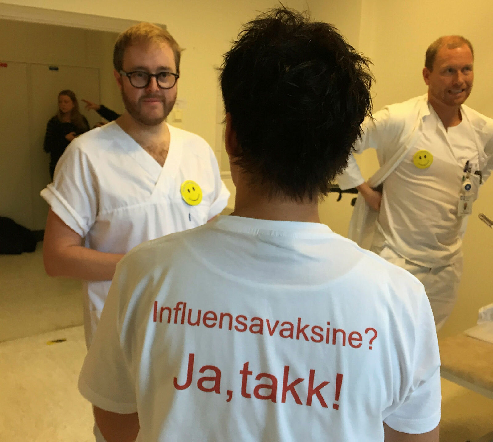 Bildet viser ryggen på en som har en t-skjorte med skriften Influensavaksine? Ja takk!