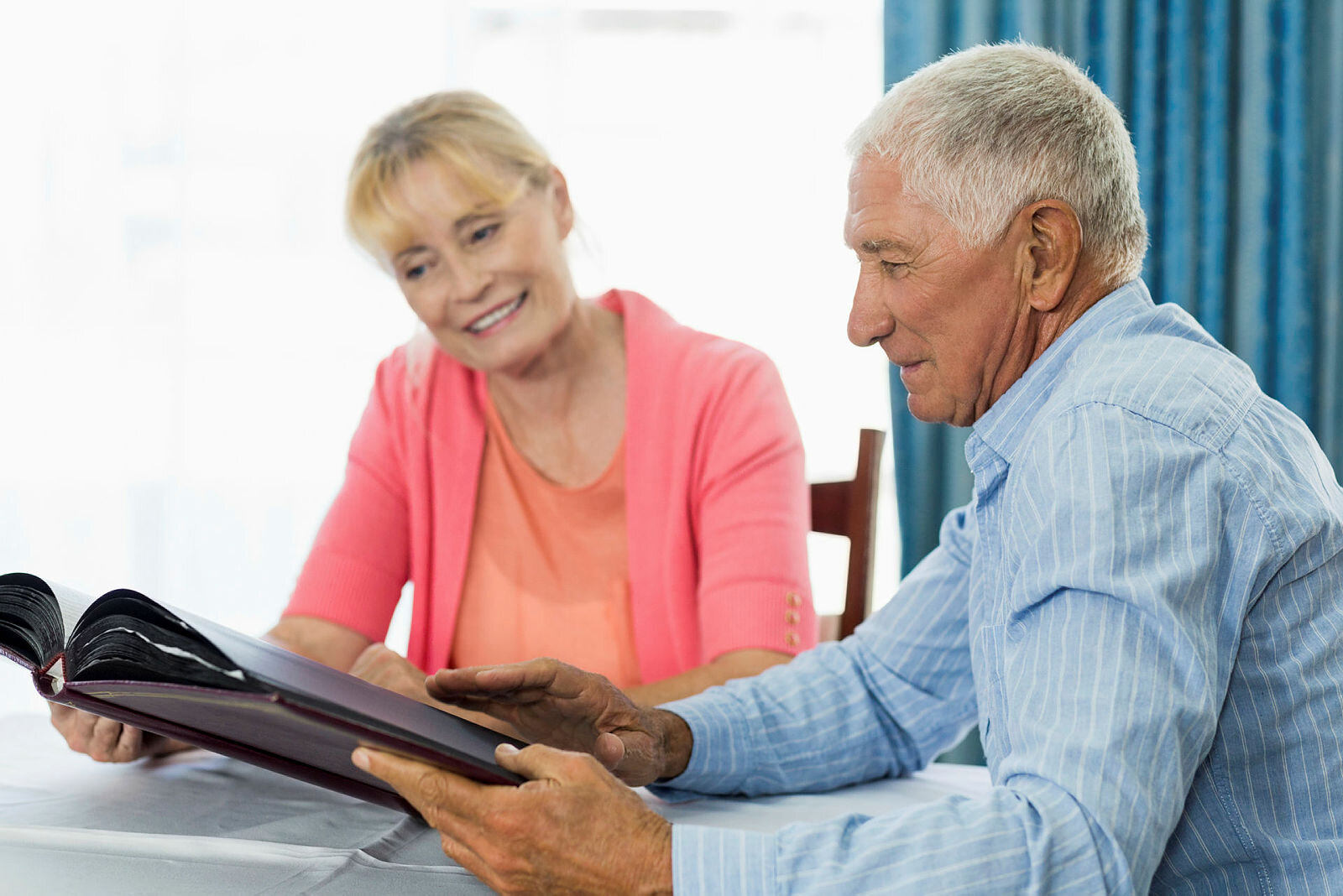 Senior couple looking at photo album in a retirement home