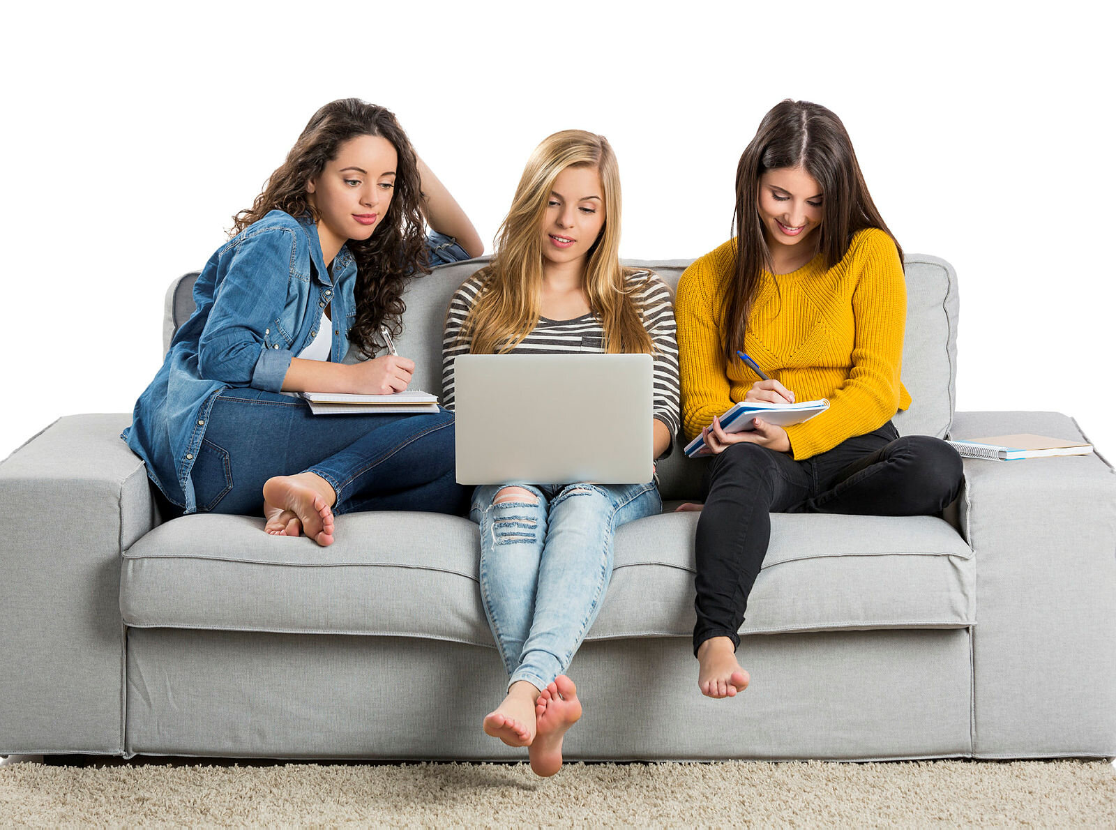 Bildet viser tre unge kvinner som sitter i en sofa med PC og kladdeblokker.