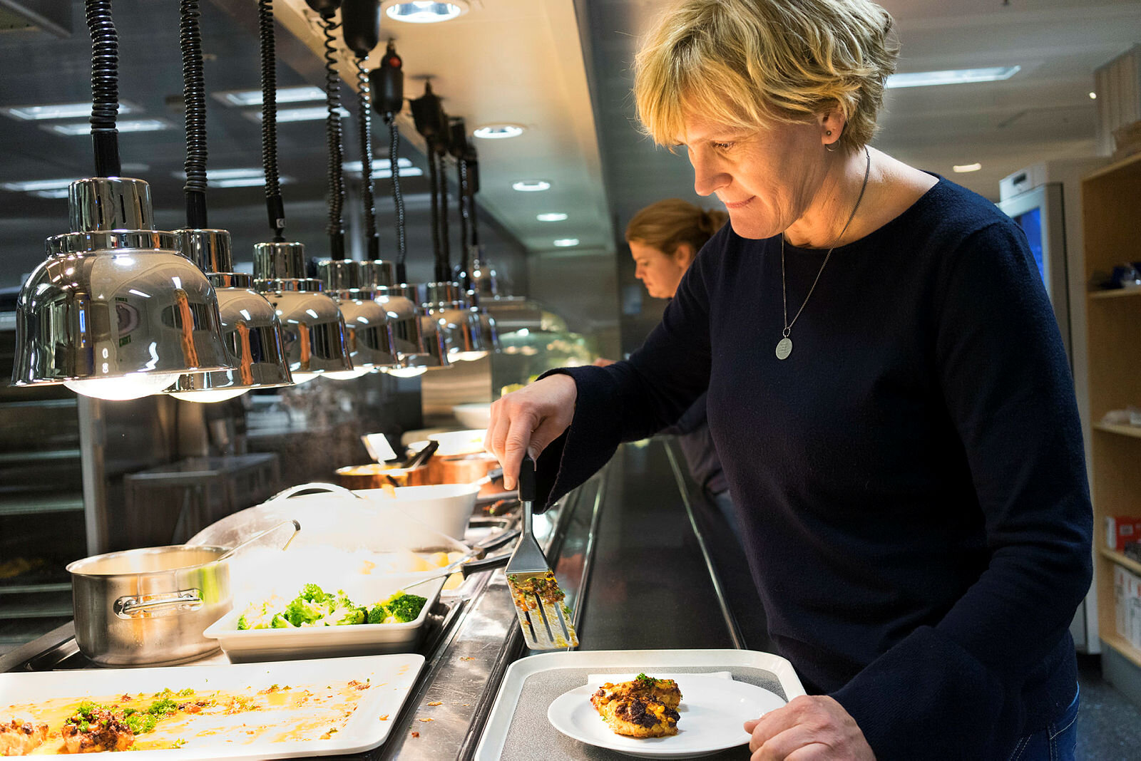 Bildet viser Wenche Vågeng forsyne seg med middag