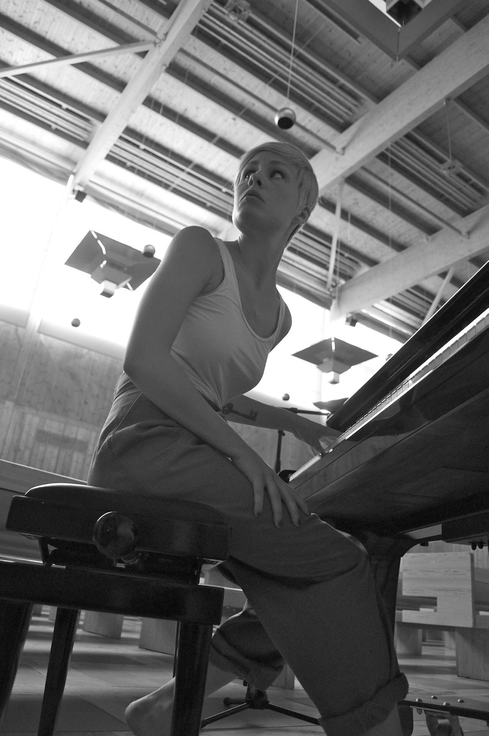 Bildet viser en ung kvinne som sitter ved et piano