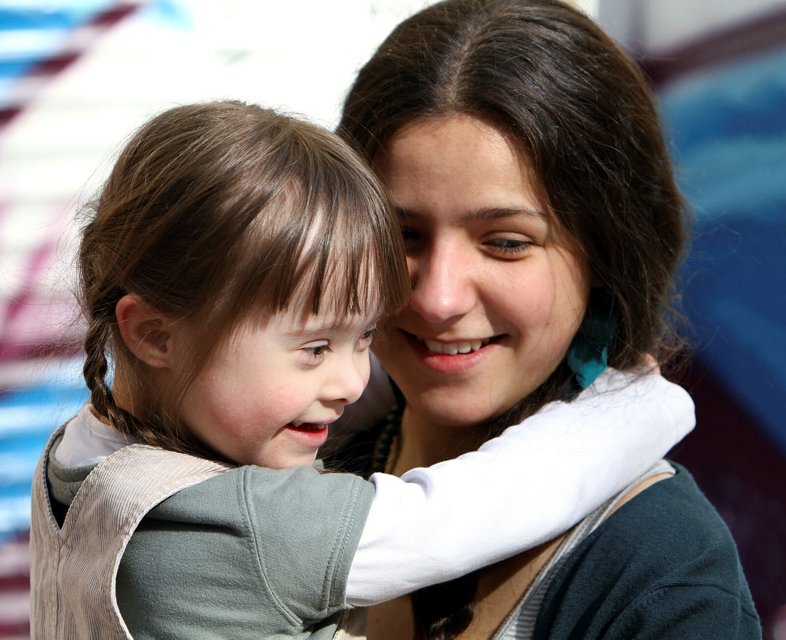 Bildet viser en lykkelig mor som holder en glad datter, som har Downs syndrom