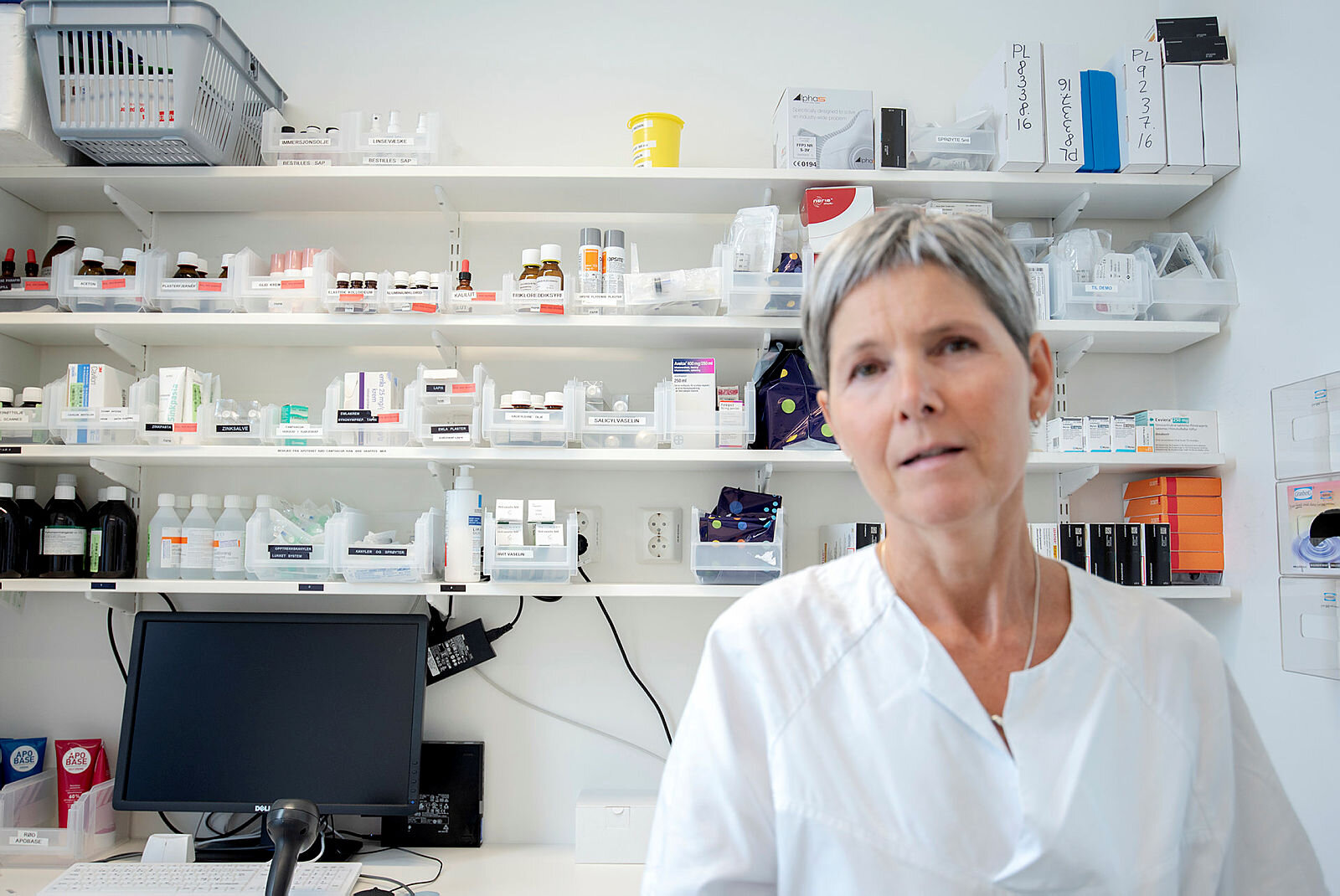 Bildet viser Ingrid Slørdal foran en hylle med medisiner.