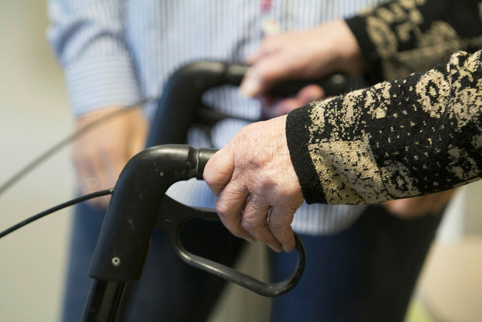 Bildet viser en gammel mann med gåstol.