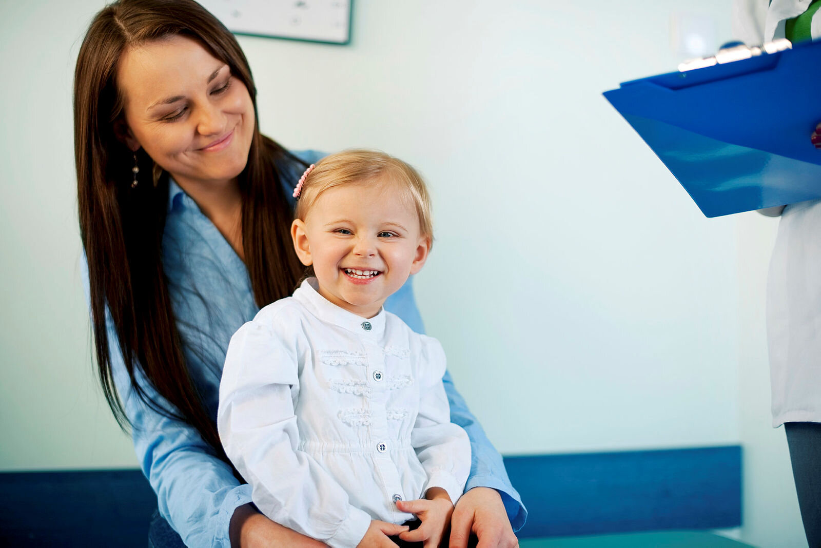 Mor og barn på sykehus. Helsepersonell gir informasjon.