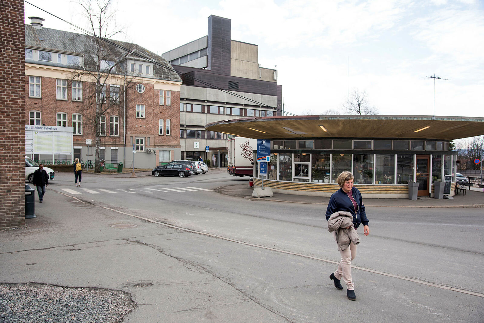 Bildet viser Karin Jonli som går ut fra Aker sykehus.