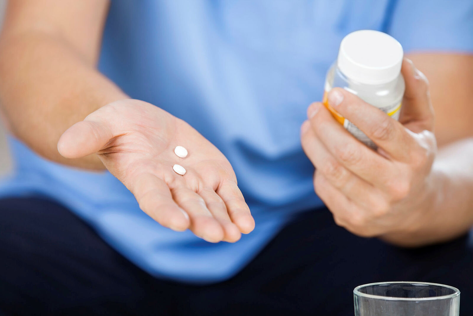Sykepleier holder piller og pilleglass.
