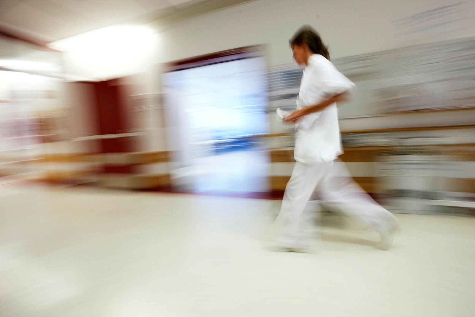 Sykepleier som løper og stresser.