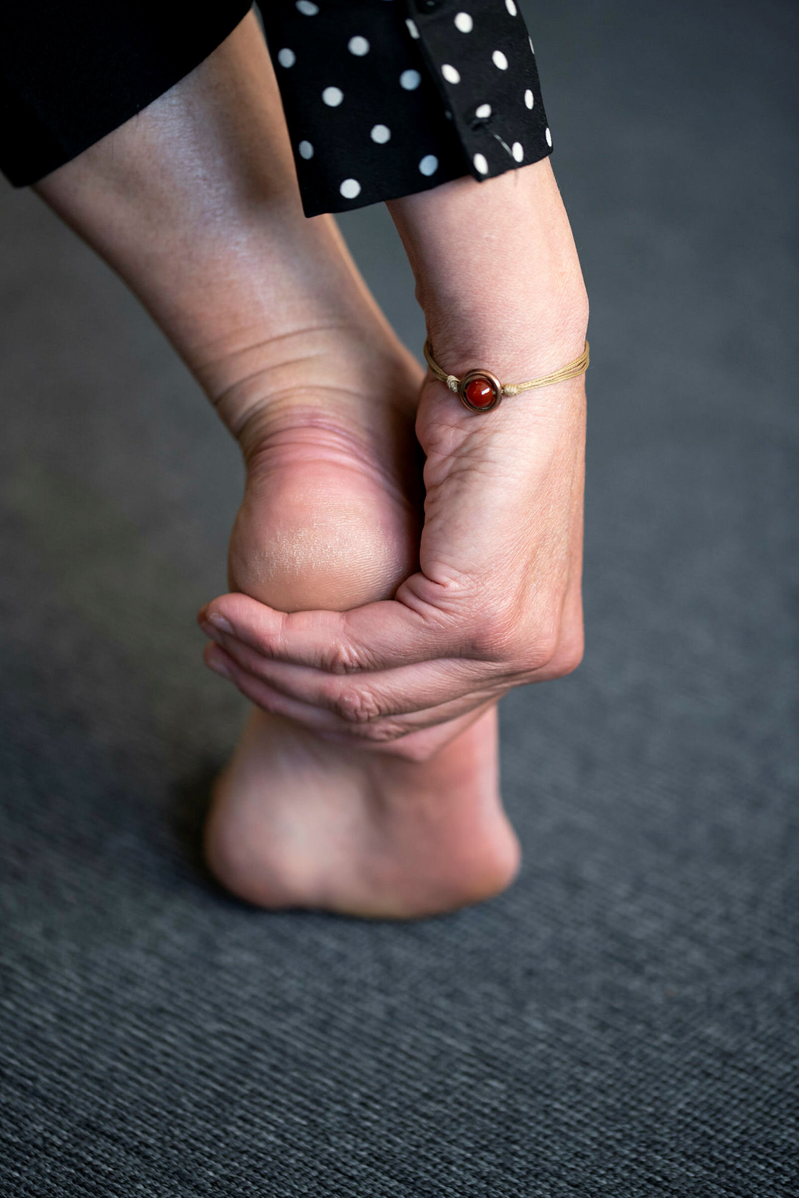 Bildet viser en hånd som rører en fot med smerter.