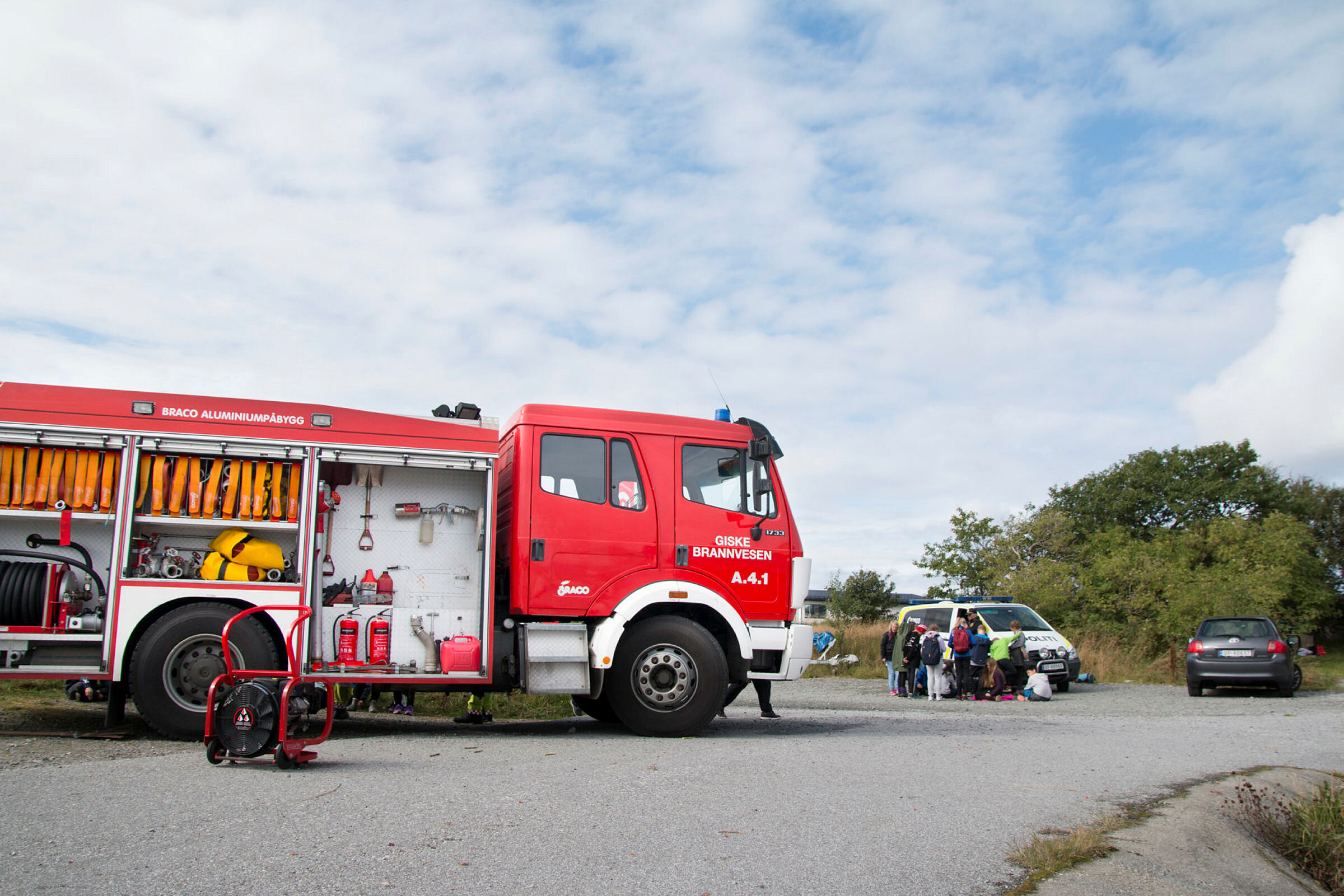 Bildet viser en brannbil med en politibil i bakgrunnen