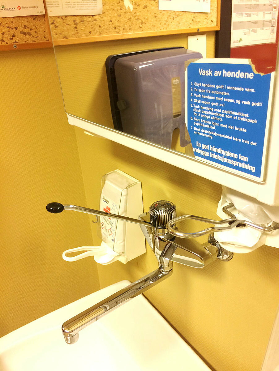 Vask av hendene instruksjon ved håndvask og såpedispenser