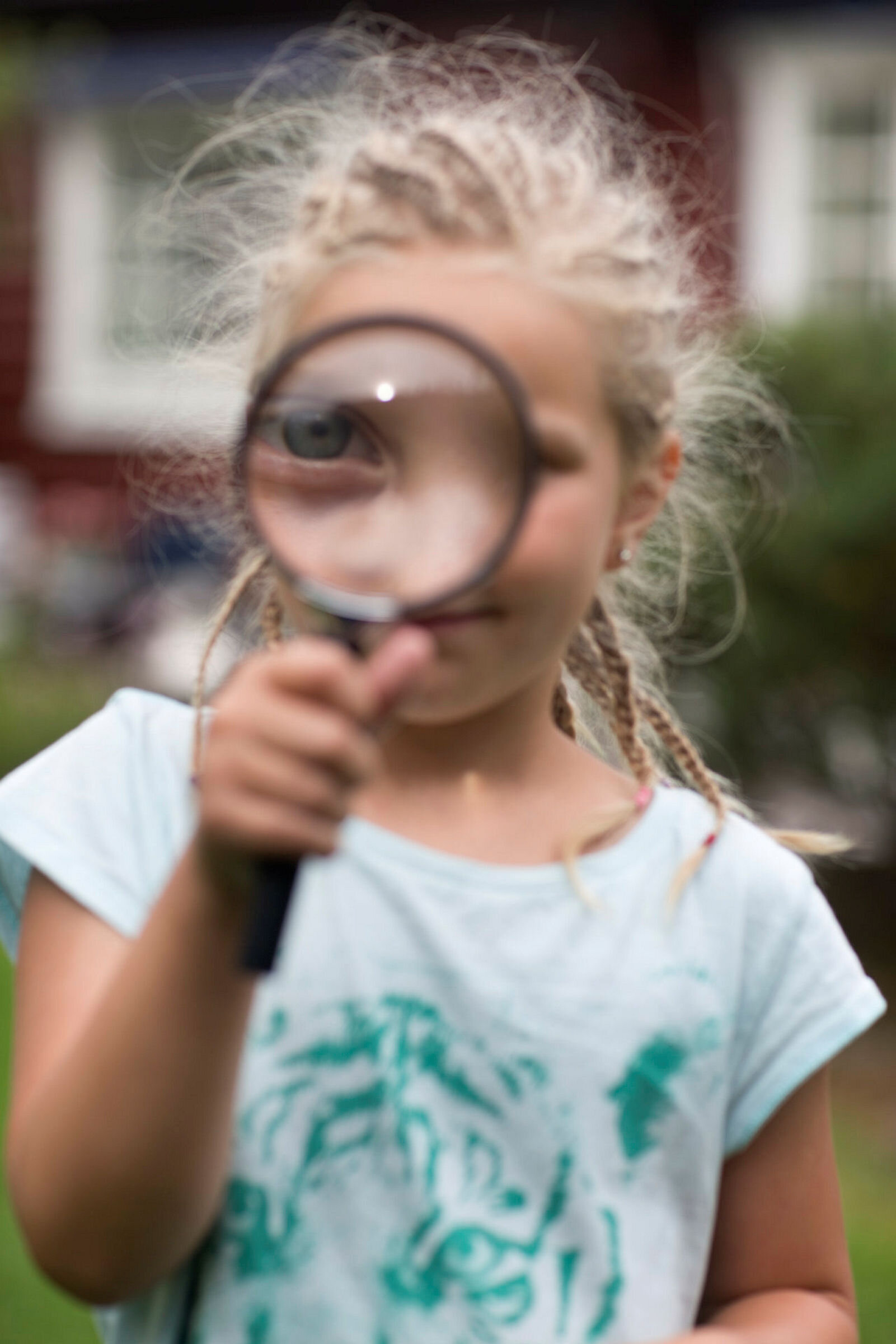 Bildet viser en jente som ser gjennom et forstørrelsesglass.
