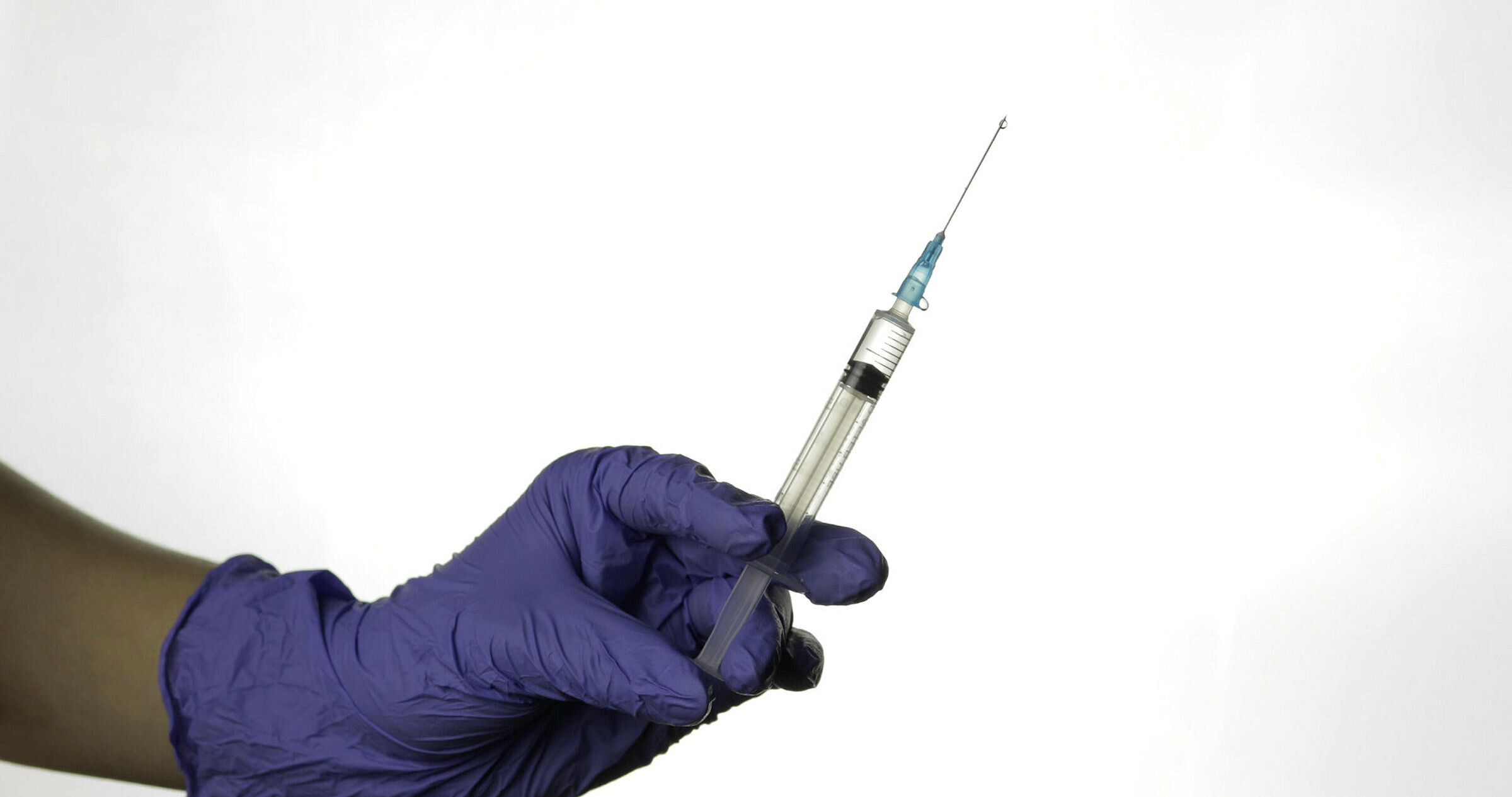 Hånd med hanske som holder sprøyte