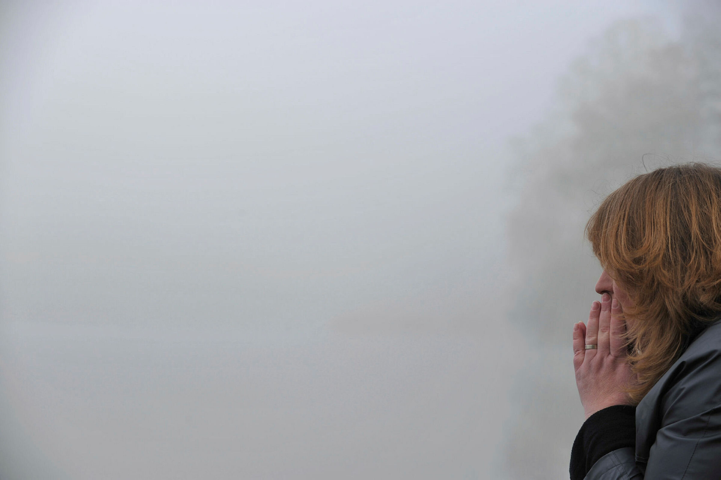 Anonymisert bilde av kvinne som ser ut i tåkelandskap