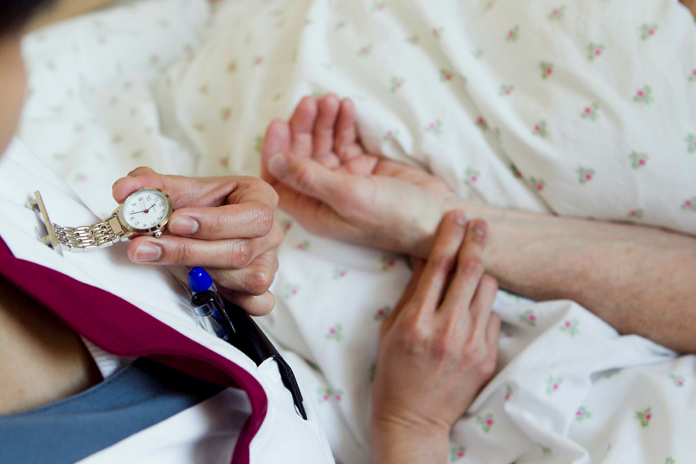 Sykepleier tar pulsen på en pasient