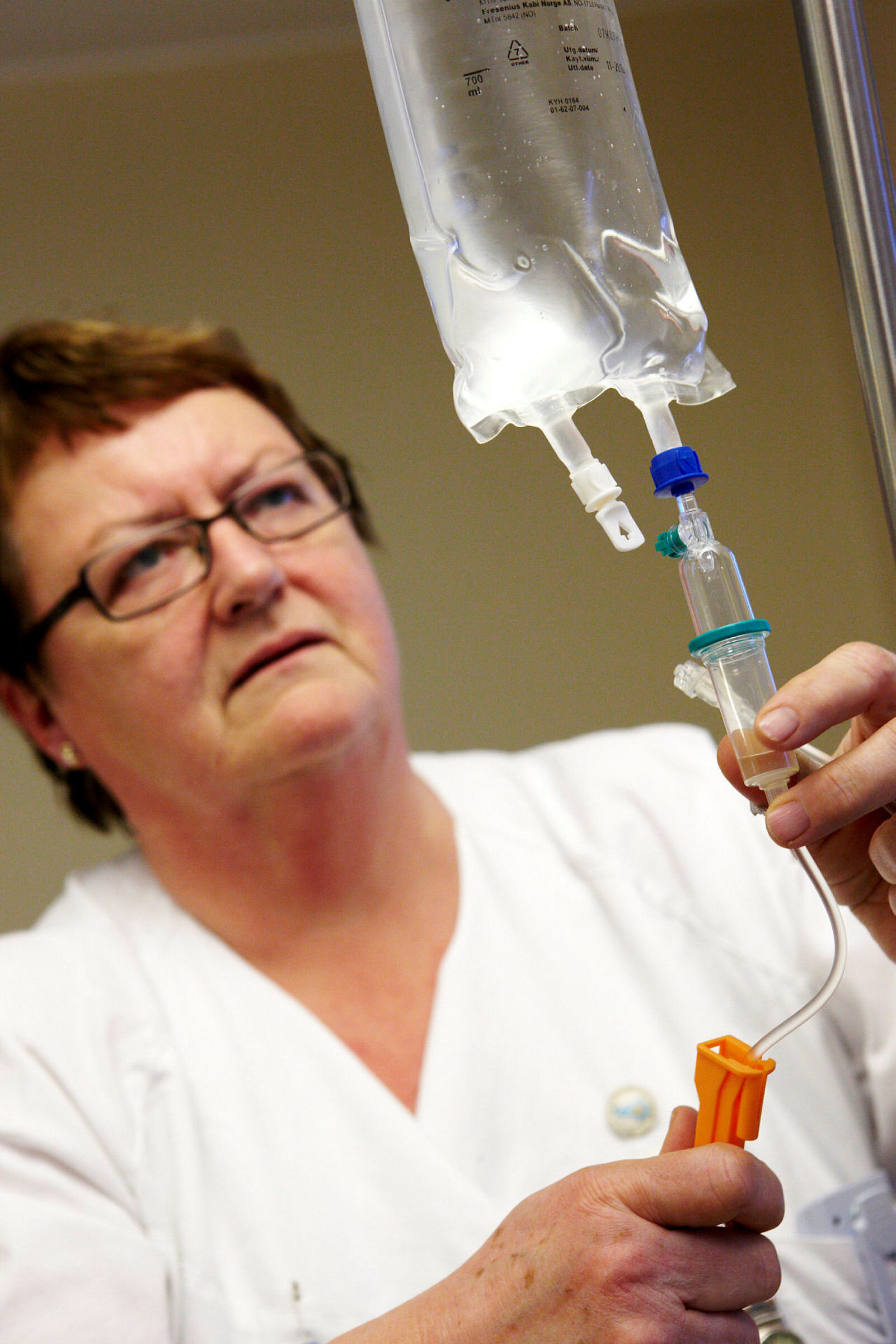 Spesialsykepleier i geriatri Bjørg Myhre forbereder intravenøs behandling.