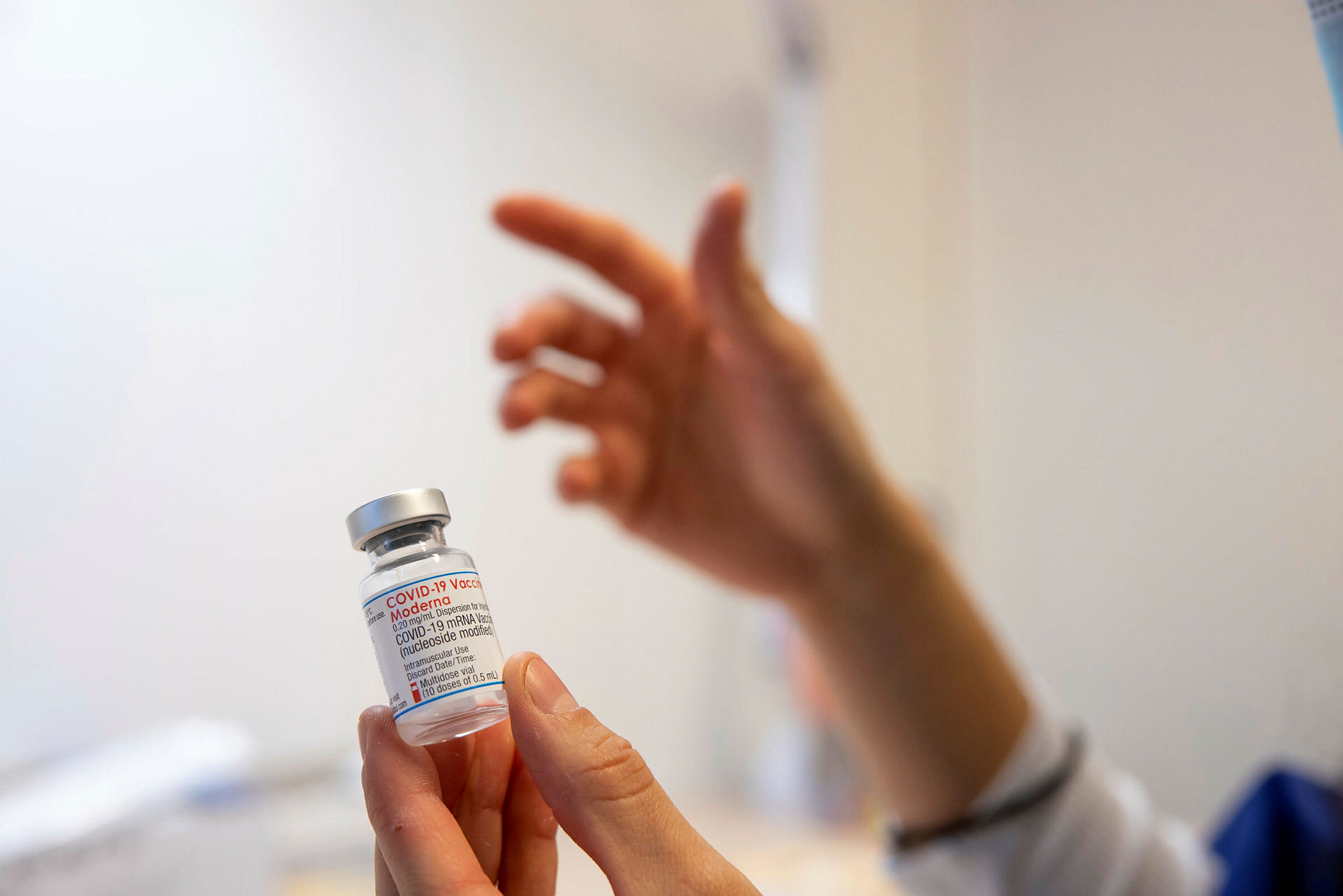 Bildet viser hender som holder et hetteglass med vaksine.