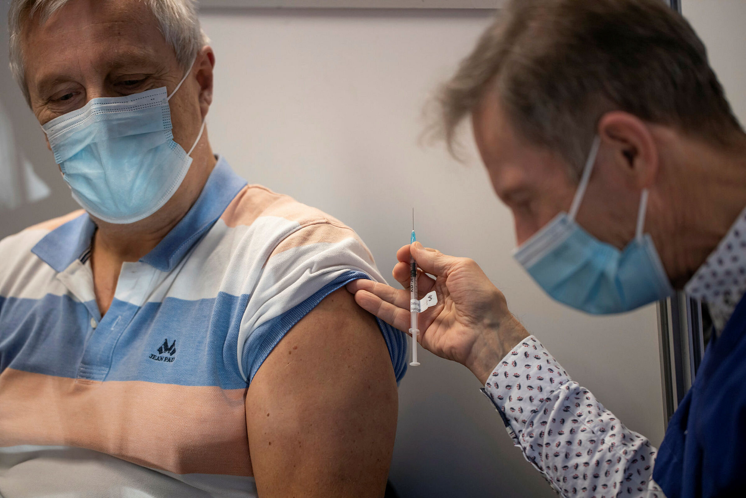 Bildet viser sykepleier som skal sette koronavaksine.