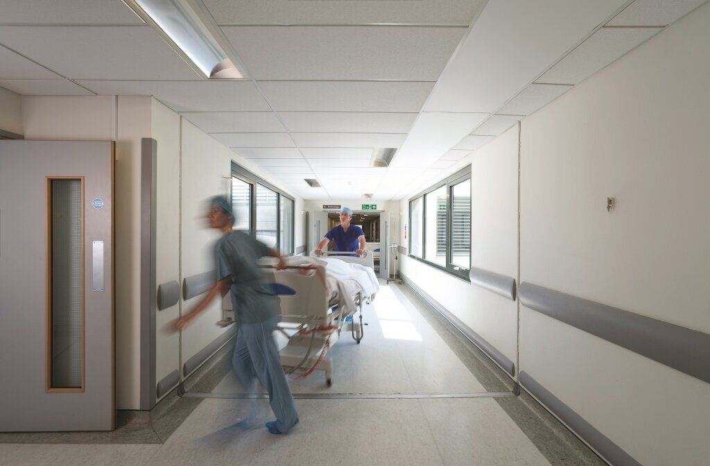 Bildet viser helsearbeidere som triller en seng.