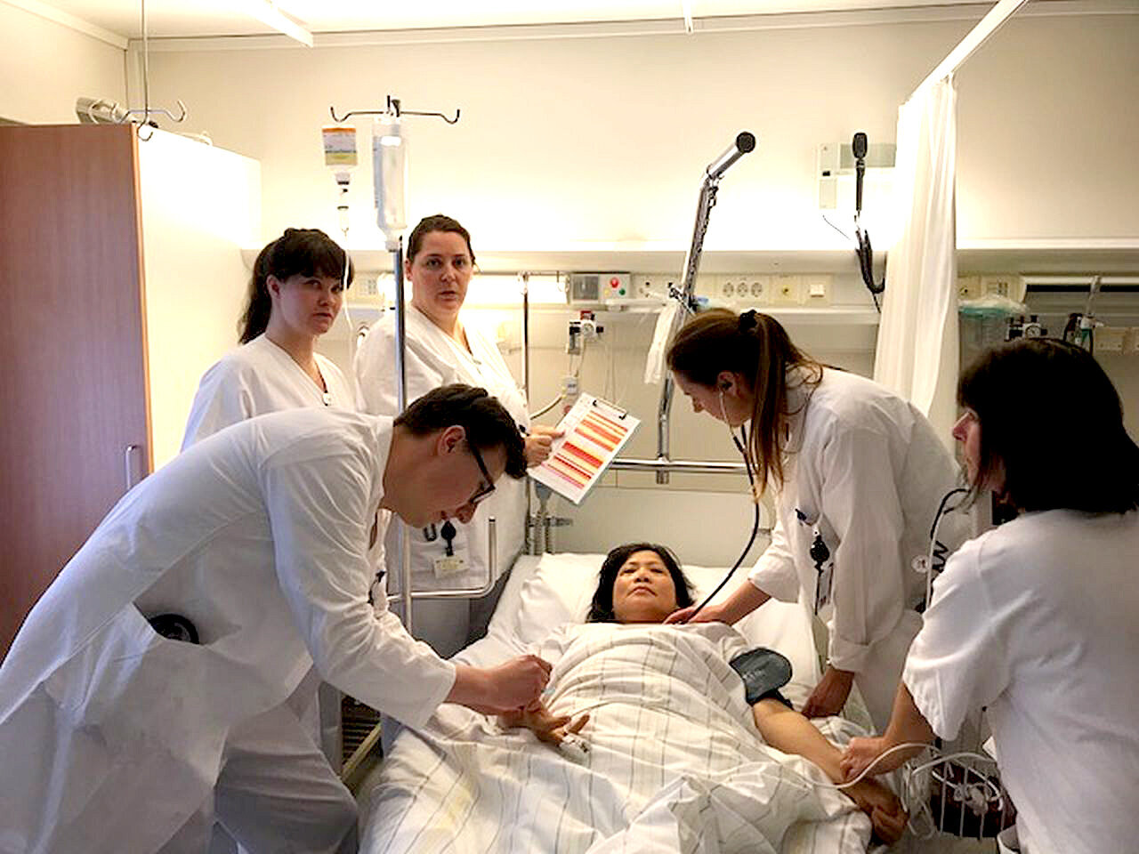 Bildet viser helsepersonell rundt en pasientseng.
