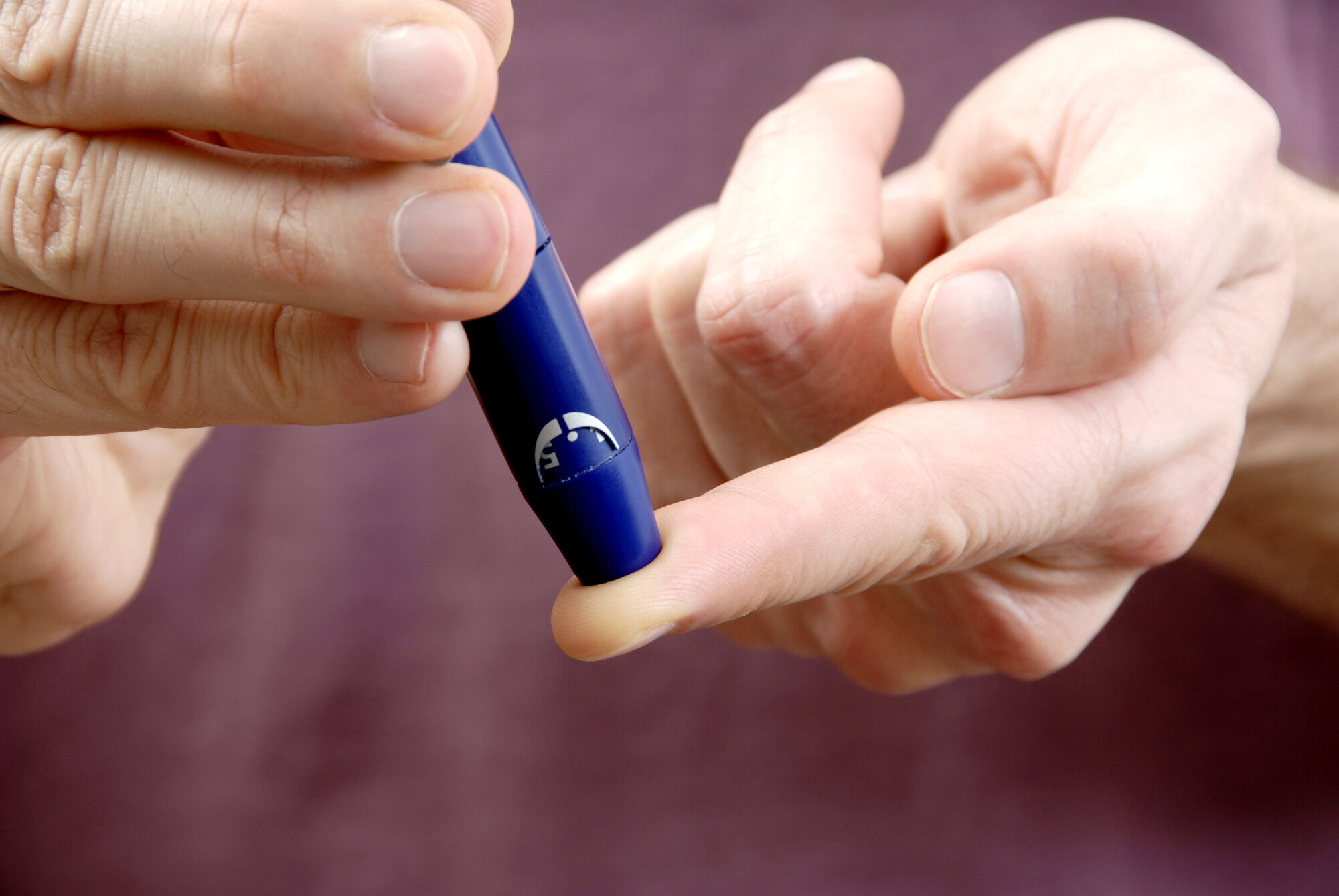 Bildet viser en person som måler blodsukkeret sitt