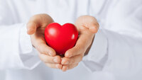Bildet viser to hender som holder et hjerte.