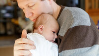 Bildet viser en far og en nyfødt baby