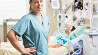 En anestesisykepleier står ved en pasient