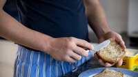 Gutt smører på brødskive