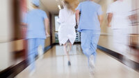 Et uklart bilde av helsepersonell som løper i gangen på et sykehus