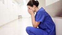 Bildet viser en stresset og sliten sykepleier