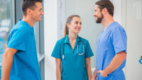 Bildet viser tre sykepleier som står og prater sammen