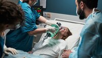 Bildet viser en traumepasient som får ventilasjon av en sykepleier i traumeteamet. Rundt sengen står flere sykepleiere