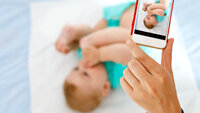 Noen tar bilde av en baby med mobiltelefonen.
