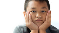 Bildet viser en liten gutt som ser ut til å ha vondt.
