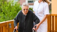 Skuffet over det offentlige tilbudet velger en del pårørende å engasjere pleiere på eget initiativ. Bildet vise eldre kvinne med gåstol som støttes av av sykepleier.