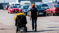 Rullestolbruker og gående på en parkeringsplass