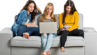 Bildet viser tre unge kvinner som sitter i en sofa med PC og kladdeblokker.