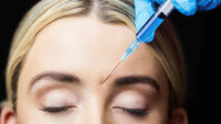 Woman receiving botox injection on her forehead Woman receiving botox injection on her forehead in a examination room