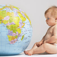 Bilde av en baby som titter på en globus