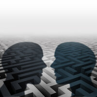 Bildet viser silhuetten av to mennesker som står ovenfor hverandre. I bakgrunnen kan man skimte en labyrint.