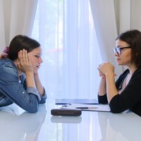 Bildet viser en ung jente og en voksen dame som snakker sammen