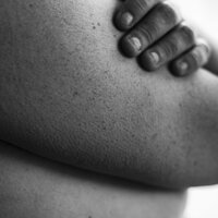 En kvinne holder armene over bysten