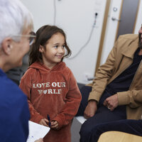 Bildet viser en familie som er på en konsultasjon hos et helsepersonell