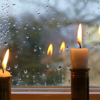 Bildet viser to stearinlys i et vindu