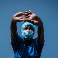 Bildet viser en sykepleier som holder hendene opp foran seg.