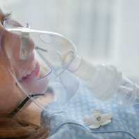 Bildet viser et barn med oksygenmaske foran ansiktet.