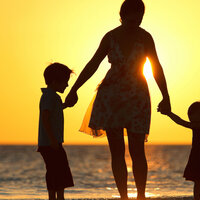 Familie i solnedgang på strand