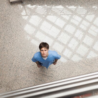 Bildet viser en sykepleier som titter opp mot kamera