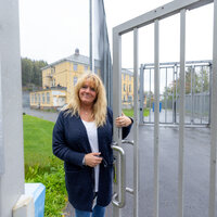 bildet viser Bente Sundbye ved den låste porten utenfor sikkerhetsavdelingen på Dikemark